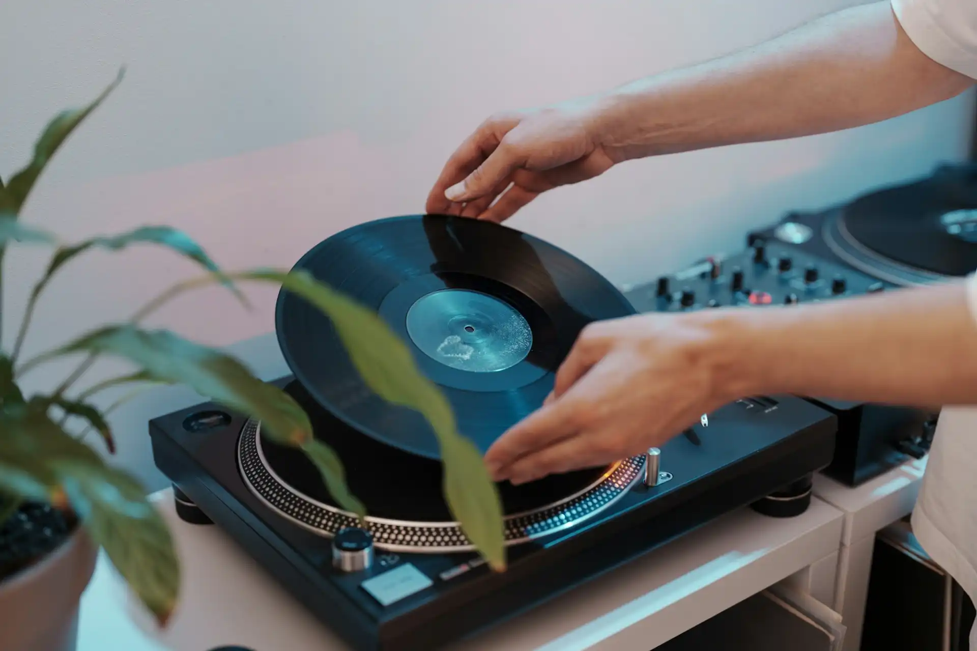 Dj placing vinyl record on turntable for music session